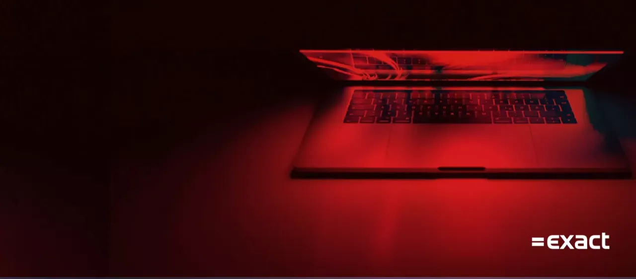 Laptop in red light with the Exact logo